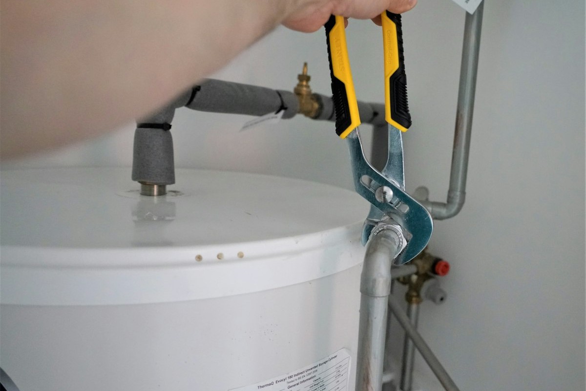 A plumber's hands finishing a repair on a water line